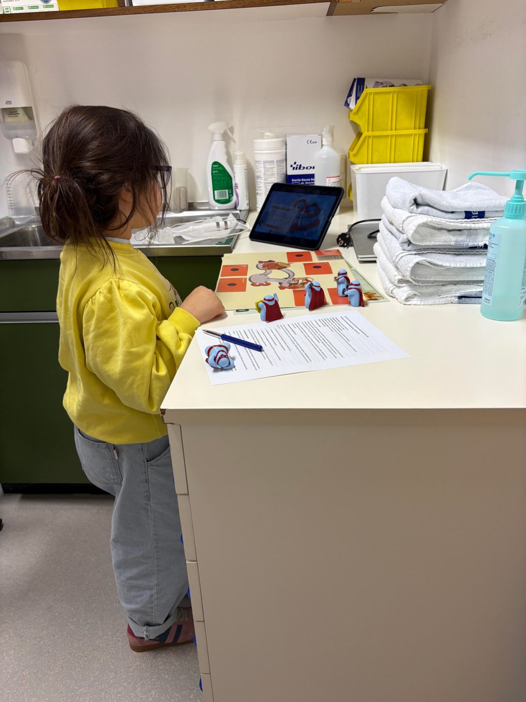 Girl testing the question sheet, hero figures and video on a tablet in a care room
