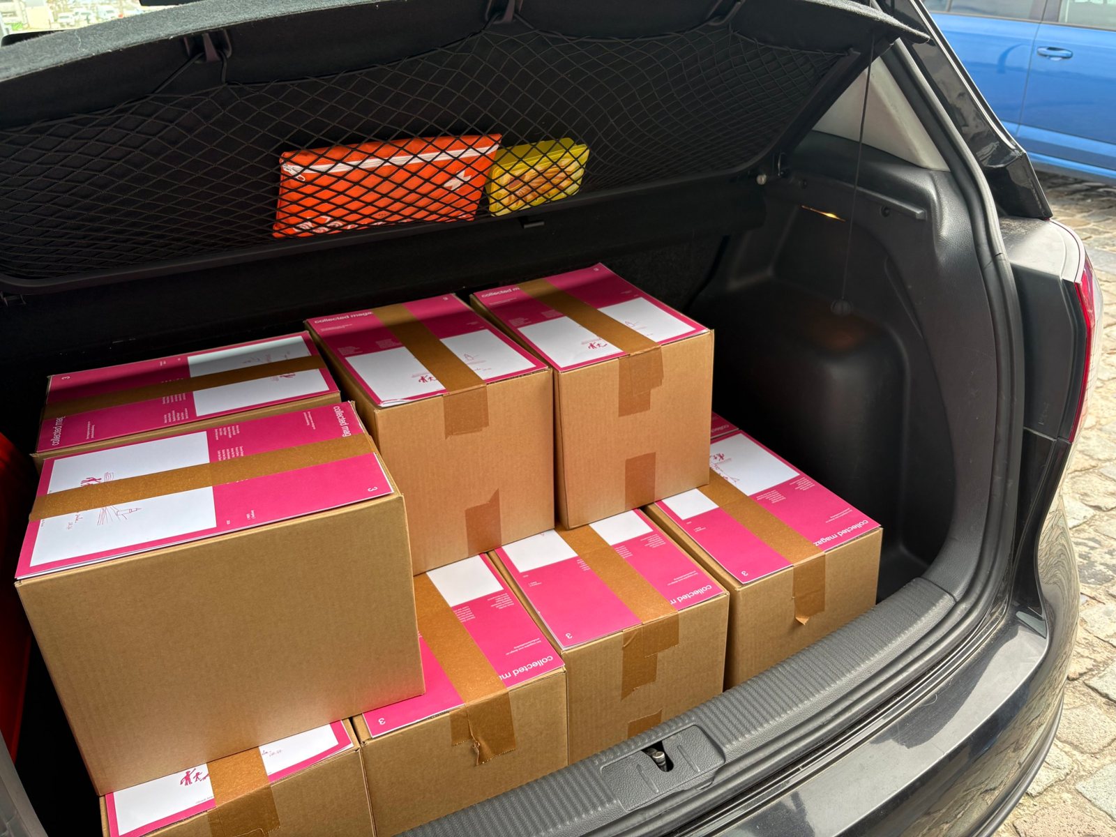 Car boot full of boxes with printed magazines