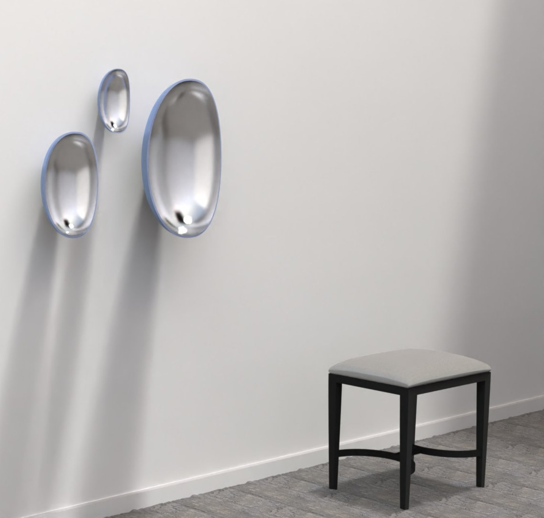 Three small egg-shaped mirrors with blue rims above a stool